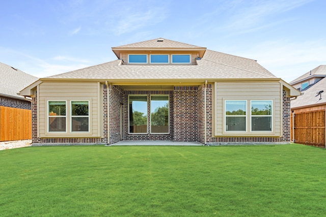 rear view of property with a yard and a patio area