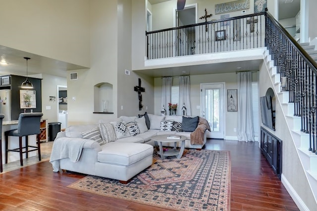 living room with dark hardwood / wood-style flooring, a high ceiling, and washer / dryer