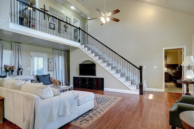 living room with wood-type flooring, high vaulted ceiling, and ceiling fan