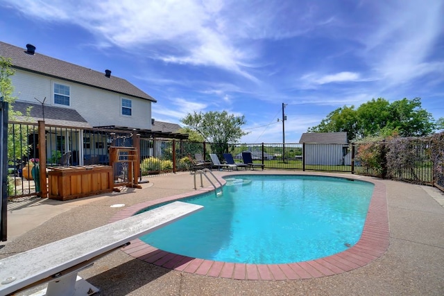 view of swimming pool featuring a patio, a diving board, a hot tub, and a storage shed