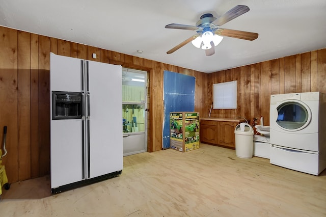 washroom with washer / dryer, wood walls, and ceiling fan