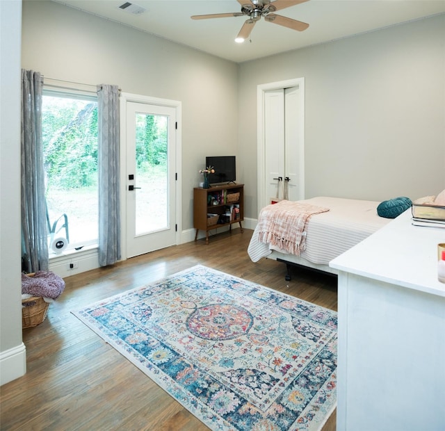 bedroom with access to exterior, wood-type flooring, and ceiling fan