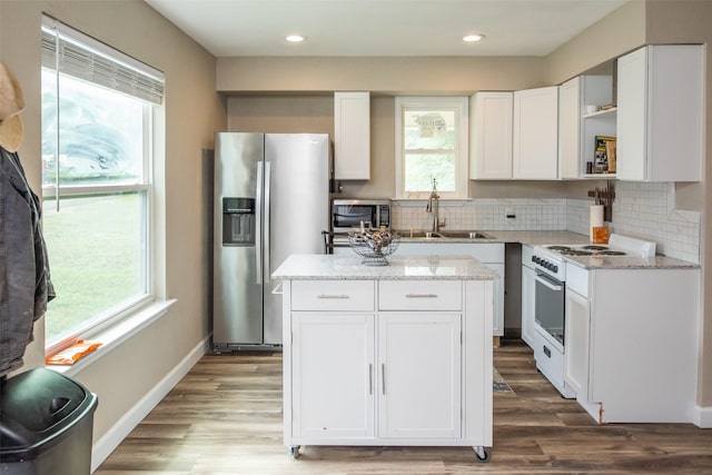 kitchen with white cabinetry, tasteful backsplash, a center island, and appliances with stainless steel finishes