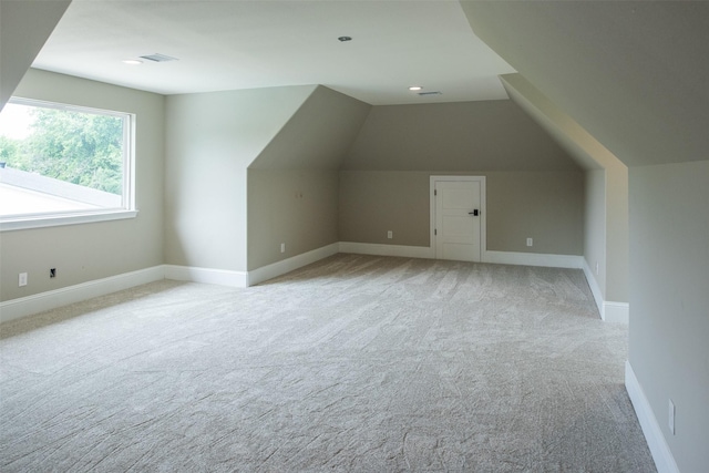 additional living space with lofted ceiling and light carpet