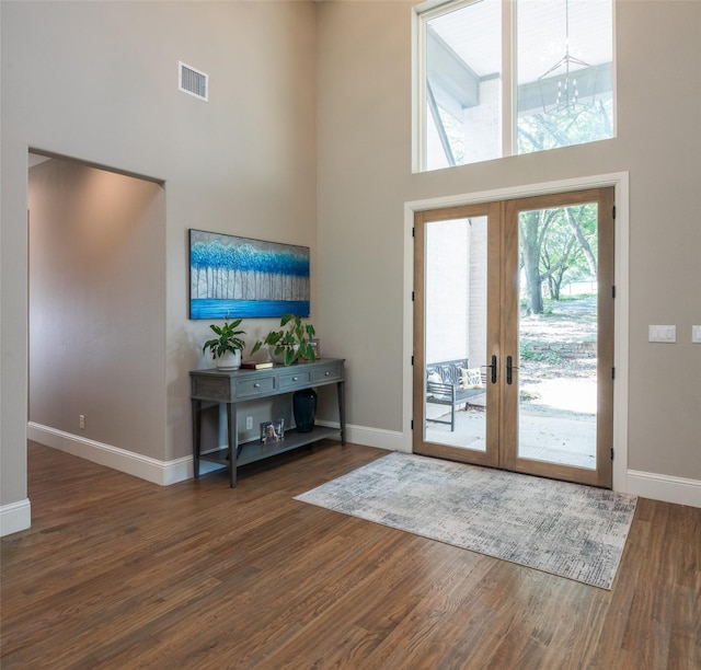 entrance foyer with french doors, dark hardwood / wood-style floors, and a high ceiling