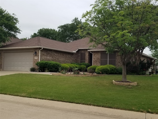 ranch-style house featuring a garage and a front lawn