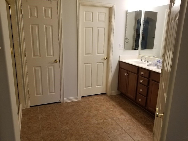 full bathroom with baseboards, vanity, and tile patterned flooring