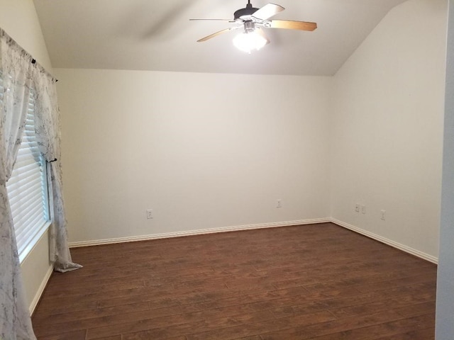 spare room with baseboards, vaulted ceiling, a ceiling fan, and dark wood-style floors