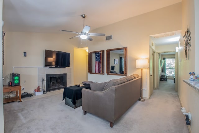 living room featuring light colored carpet, a tile fireplace, ceiling fan, and vaulted ceiling