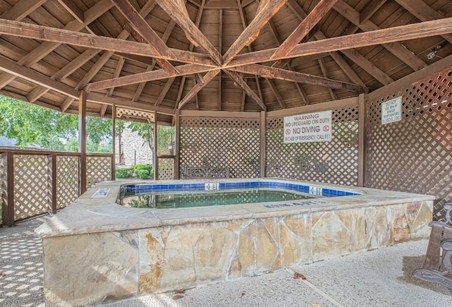 exterior space with a jacuzzi and vaulted ceiling