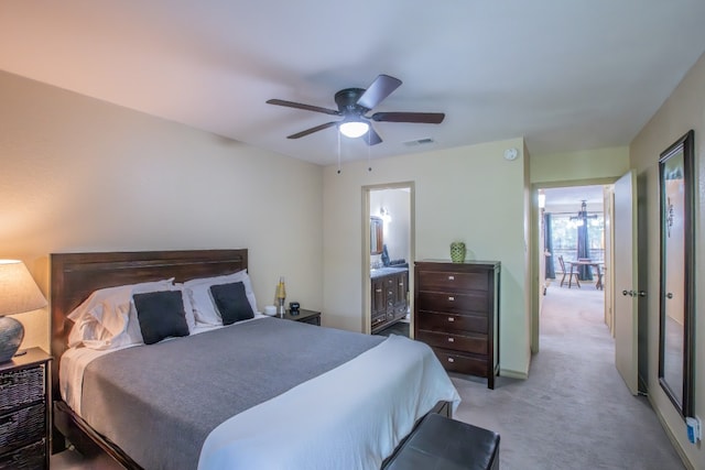 bedroom featuring light carpet, ceiling fan, and ensuite bathroom