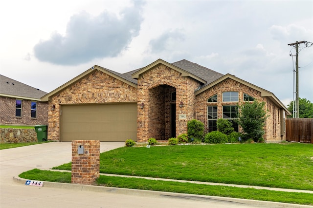 view of front of property with a garage and a front lawn