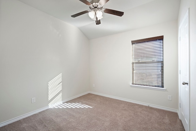 carpeted empty room featuring vaulted ceiling and ceiling fan