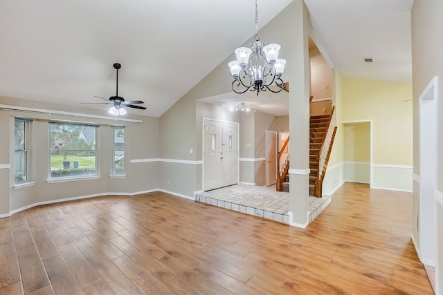 unfurnished living room featuring ceiling fan with notable chandelier, light hardwood / wood-style floors, and lofted ceiling