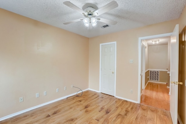 unfurnished bedroom featuring ceiling fan, a textured ceiling, and light hardwood / wood-style flooring