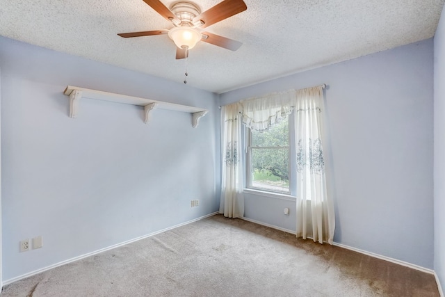 empty room with ceiling fan, light colored carpet, and a textured ceiling