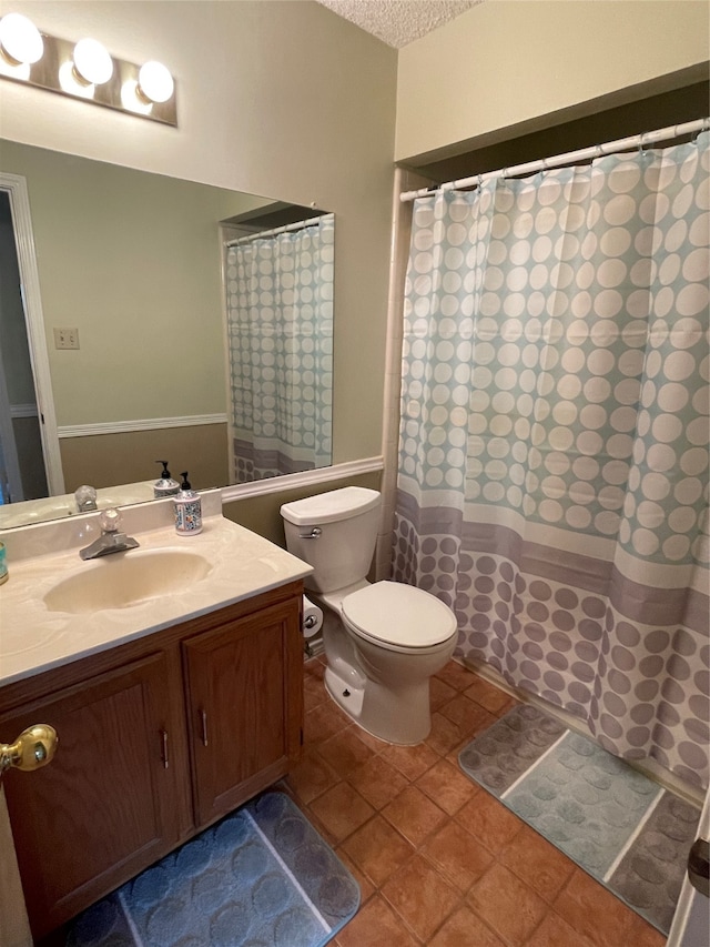 bathroom featuring tile patterned flooring, vanity, toilet, and a textured ceiling