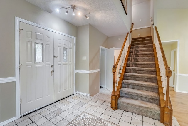 foyer with light tile patterned floors and a textured ceiling