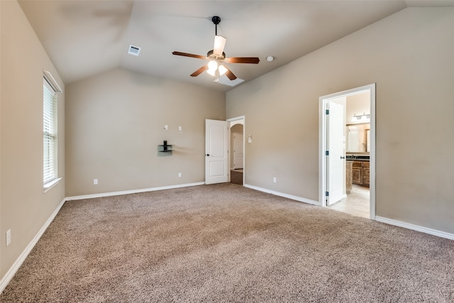 unfurnished bedroom featuring connected bathroom, vaulted ceiling, ceiling fan, and light colored carpet