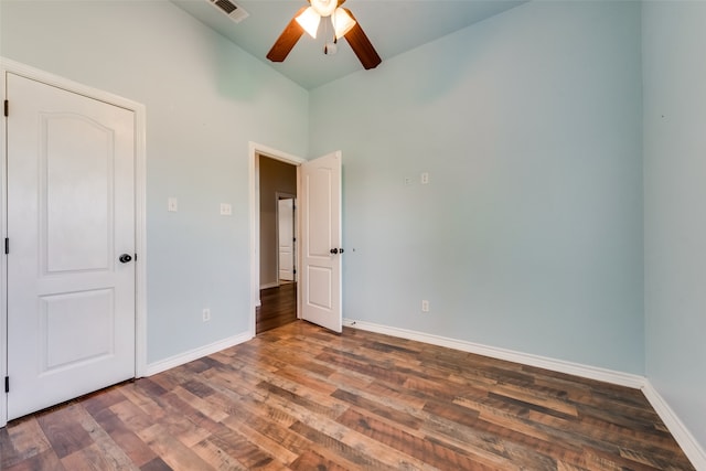 unfurnished bedroom with vaulted ceiling, dark hardwood / wood-style flooring, and ceiling fan