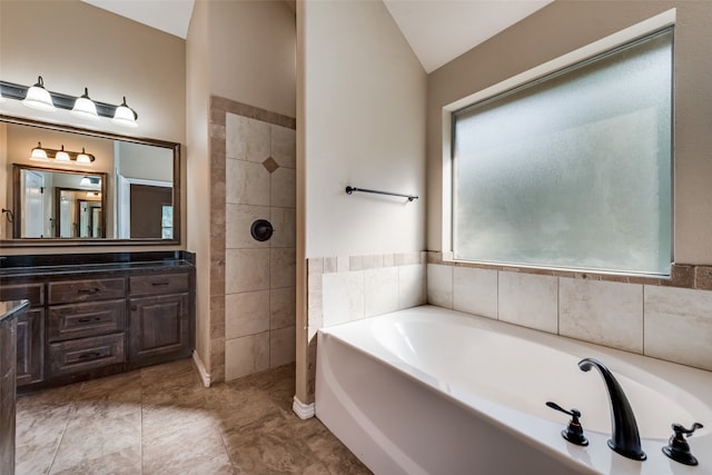 bathroom featuring plus walk in shower, lofted ceiling, plenty of natural light, and vanity