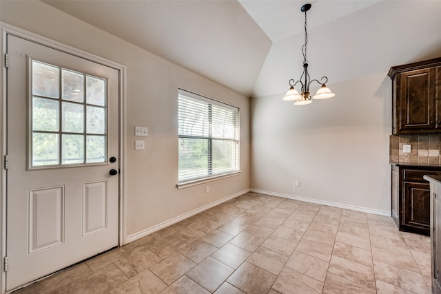 interior space featuring a notable chandelier, vaulted ceiling, and light tile patterned flooring