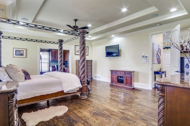 bedroom with a tray ceiling, dark hardwood / wood-style floors, ceiling fan, and crown molding