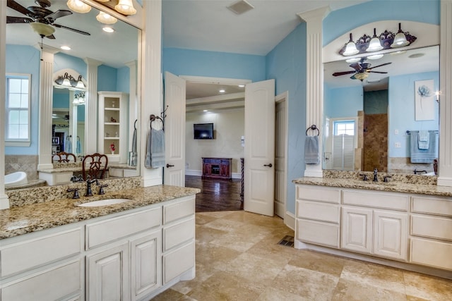 bathroom featuring ceiling fan, double vanity, crown molding, wood-type flooring, and ornate columns