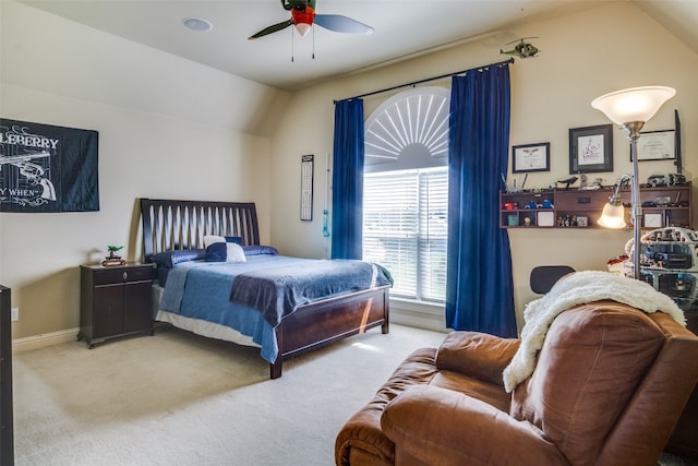 carpeted bedroom with ceiling fan and vaulted ceiling