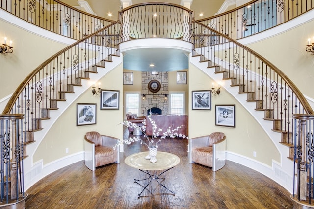 interior space with a fireplace, dark hardwood / wood-style flooring, and a towering ceiling