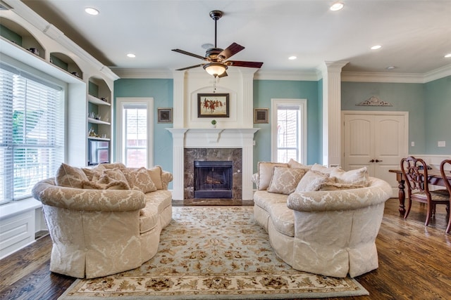 living room featuring a healthy amount of sunlight, ceiling fan, a fireplace, and dark wood-type flooring