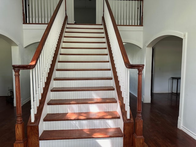 stairway featuring hardwood / wood-style floors and a high ceiling