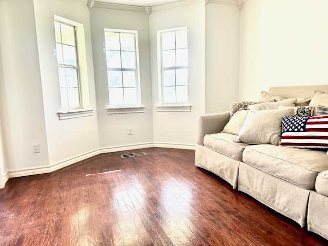 unfurnished living room featuring ornamental molding, a healthy amount of sunlight, and dark hardwood / wood-style floors