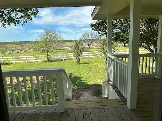 wooden terrace featuring a yard and a rural view