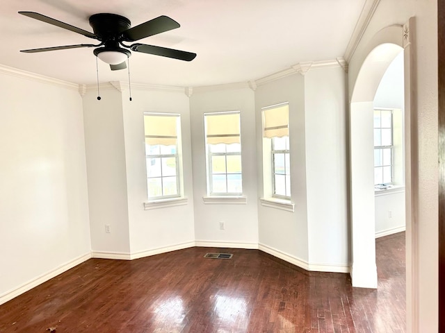 spare room featuring crown molding, plenty of natural light, and dark wood-type flooring