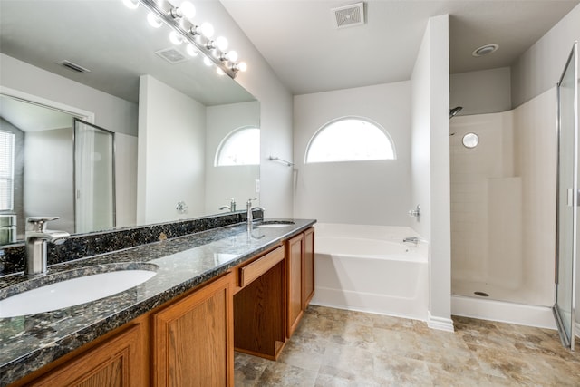 bathroom featuring plus walk in shower, dual vanity, and tile patterned floors