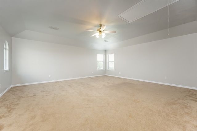 empty room featuring light carpet, ceiling fan, and vaulted ceiling