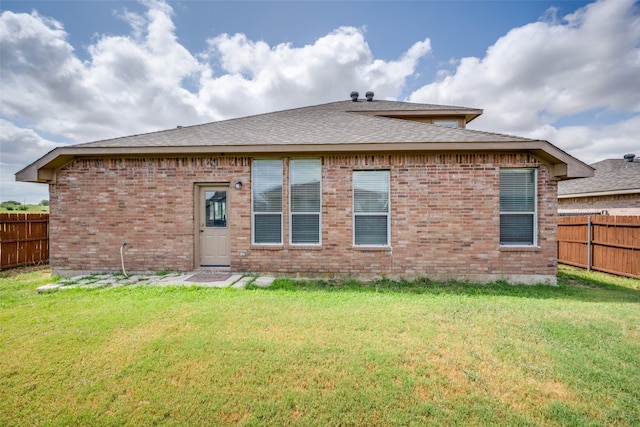 rear view of property with a lawn