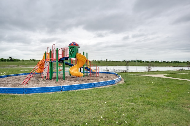 view of playground with a water view and a lawn