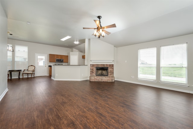 unfurnished living room featuring dark hardwood / wood-style flooring, a brick fireplace, and ceiling fan