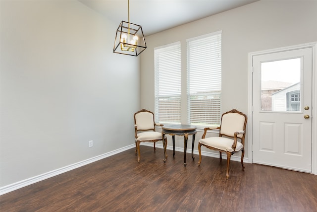 living area featuring dark wood-type flooring and a notable chandelier