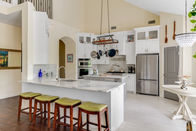 kitchen with tasteful backsplash, kitchen peninsula, sink, and stainless steel appliances