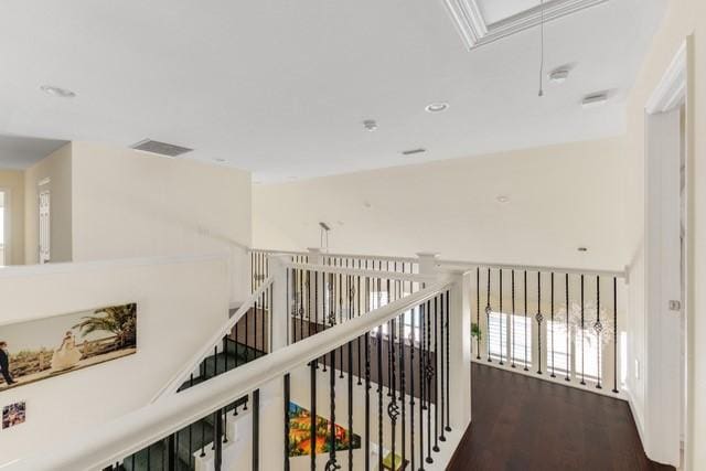 hallway with attic access, visible vents, wood finished floors, and recessed lighting