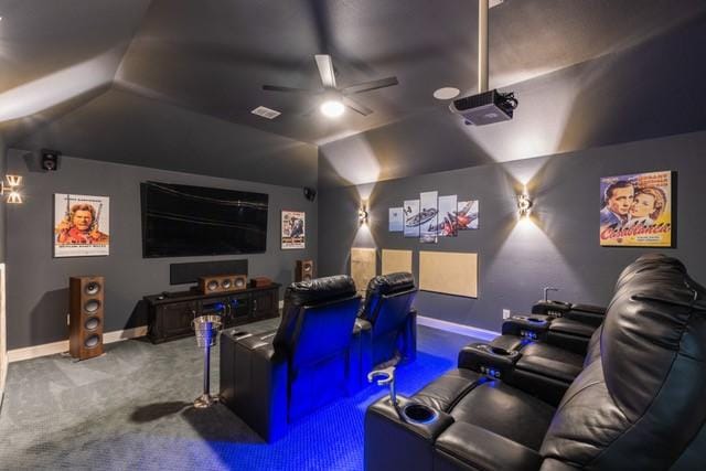 home theater with lofted ceiling, carpet floors, ceiling fan, and baseboards