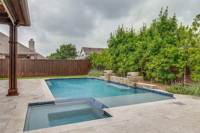 view of swimming pool with a pool with connected hot tub, a patio area, and a fenced backyard