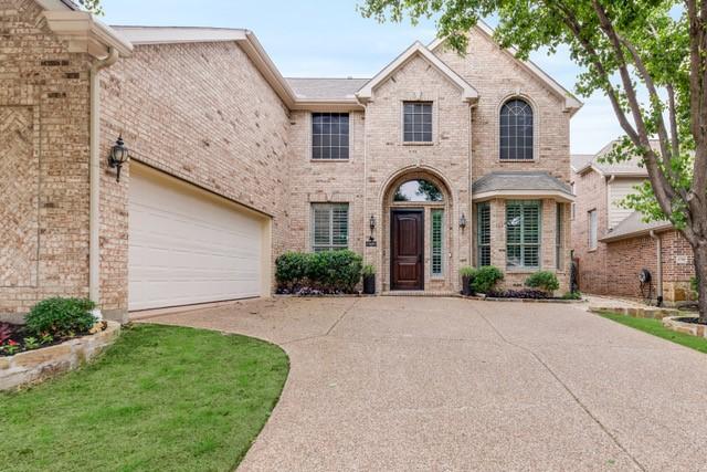 view of front facade with driveway and brick siding