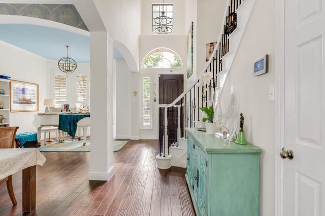 living room with hardwood / wood-style flooring, crown molding, and an inviting chandelier