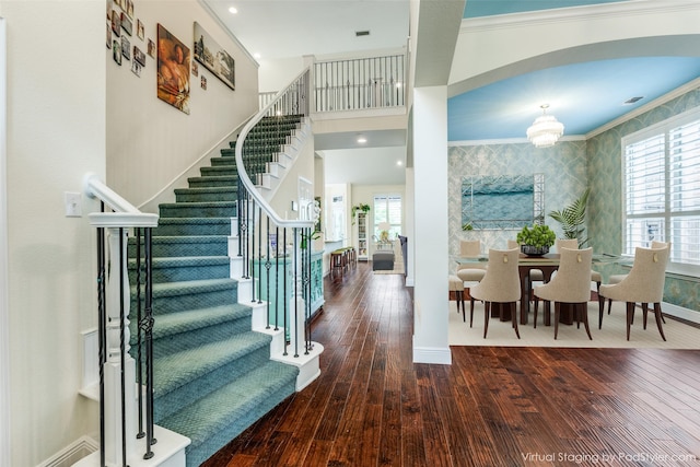 entryway featuring crown molding, hardwood / wood-style floors, and a notable chandelier