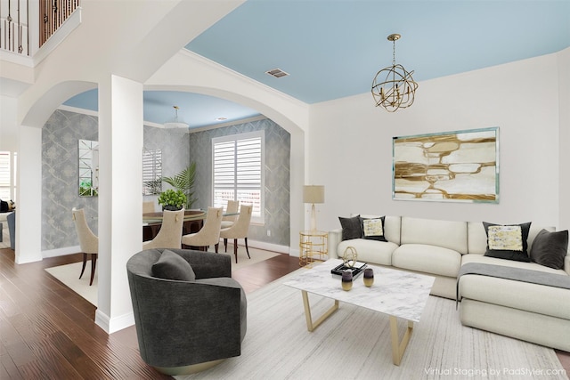 living area featuring baseboards, wood finished floors, visible vents, and an inviting chandelier