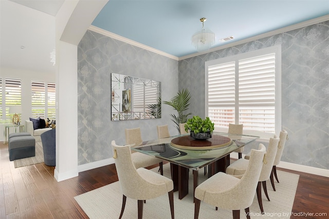 dining space featuring arched walkways, visible vents, wood finished floors, baseboards, and wallpapered walls